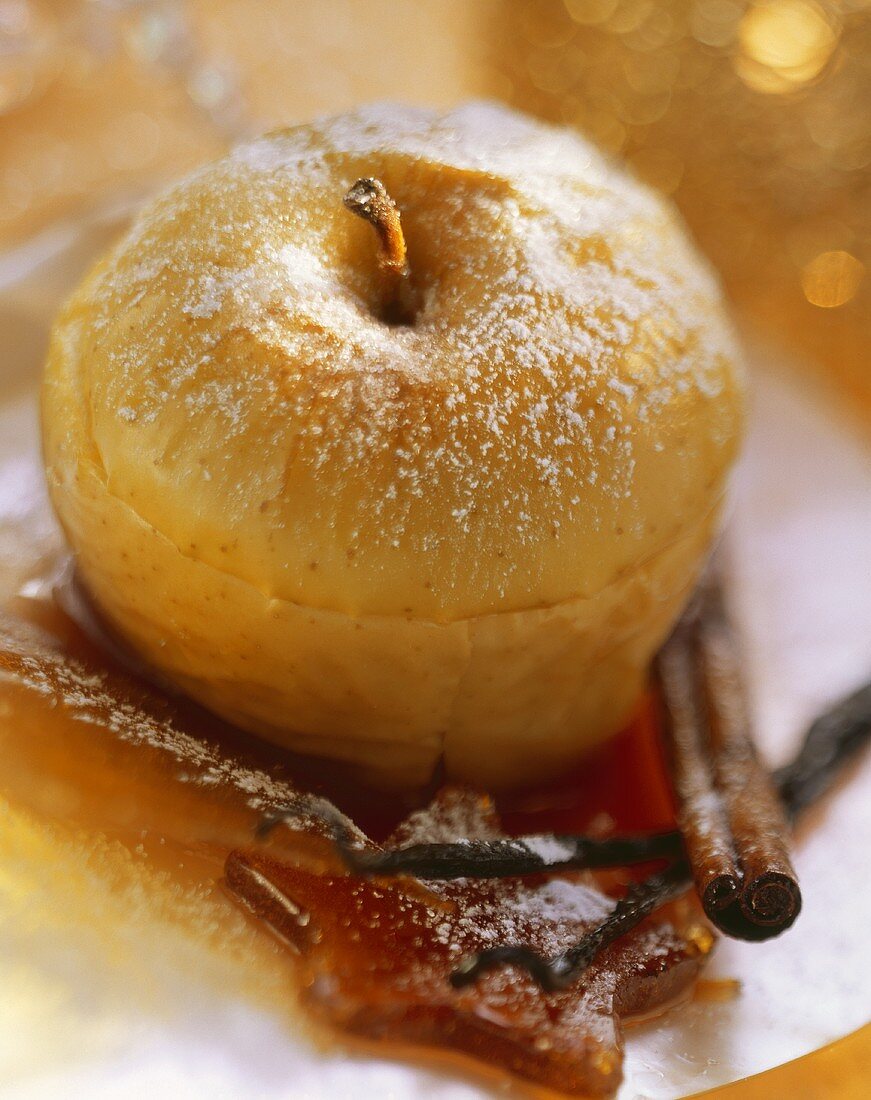Ginger baked apples with icing sugar, caramel & cinnamon stick