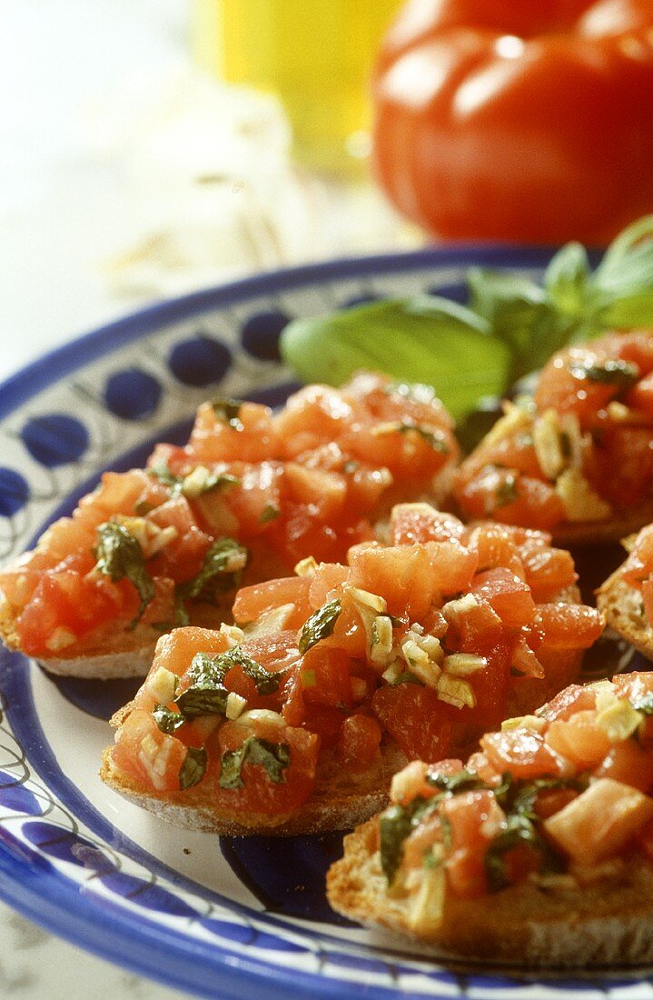 Bruschetta mit gehacktem Basilikum; frische Tomaten; Olivenöl