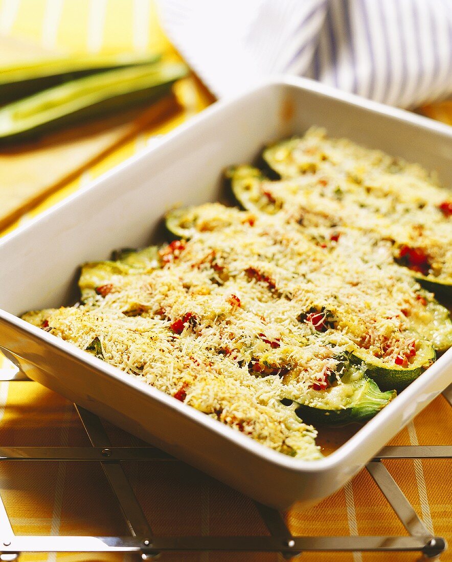 Courgette boats with herbs in baking dish