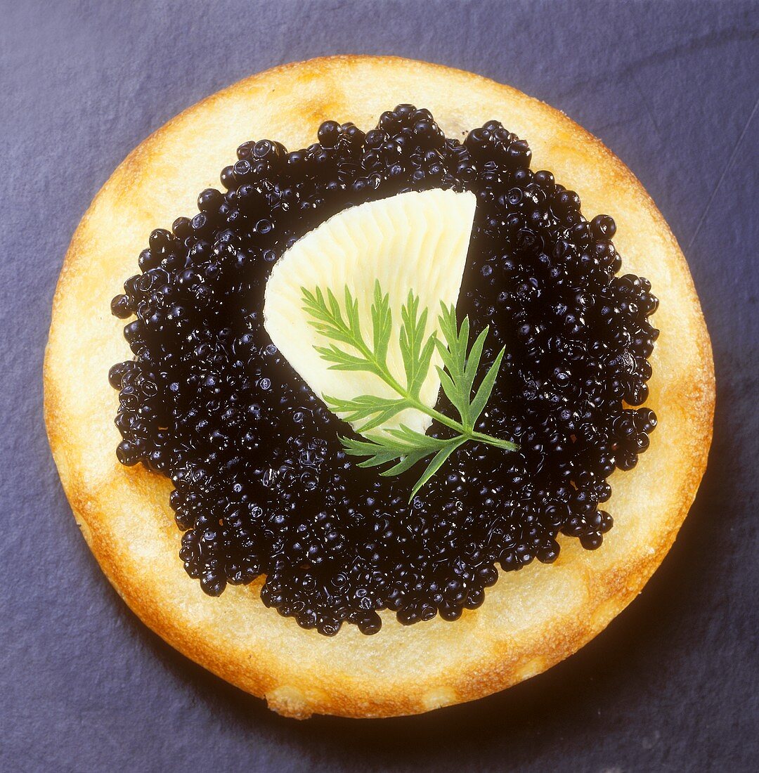 Blini with caviare and lemon wedge