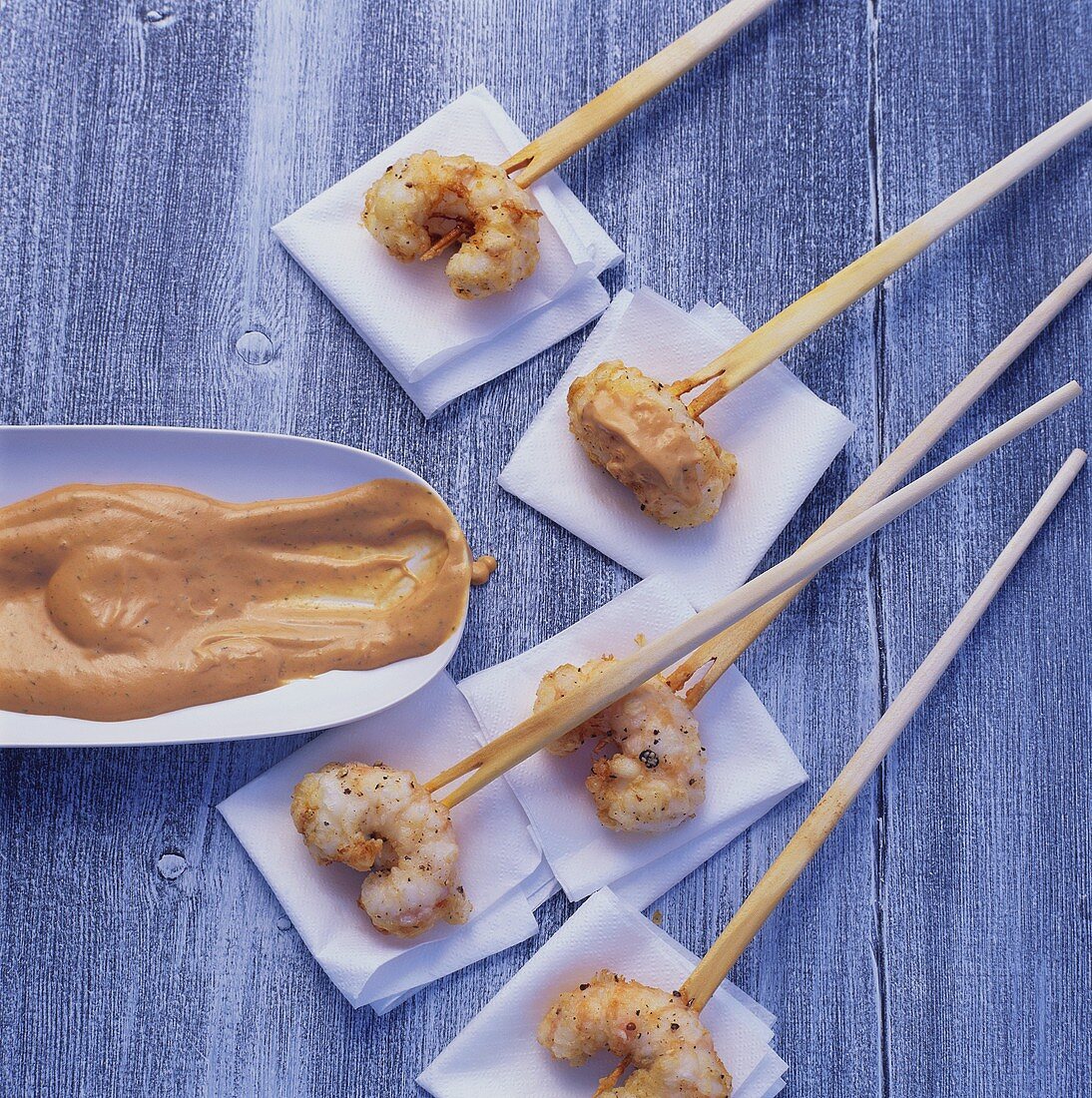 Shrimps on wooden cocktail sticks with dip