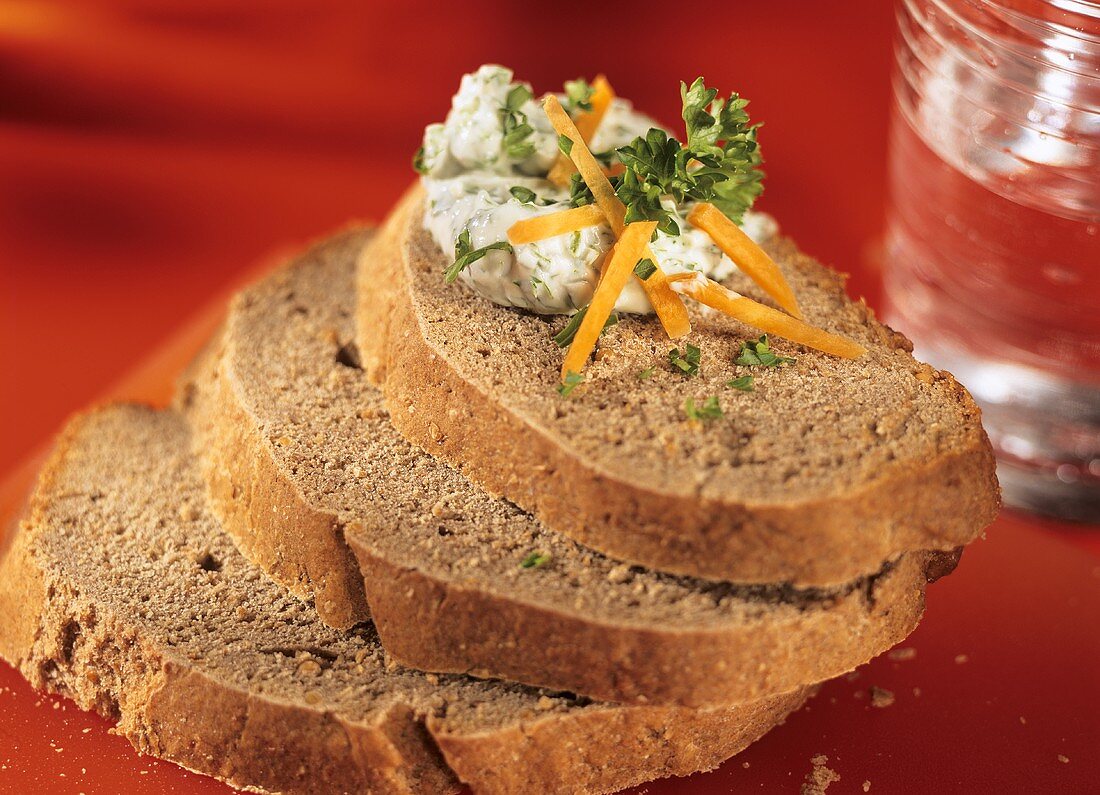 Three slices of buckwheat bread, one with herb quark