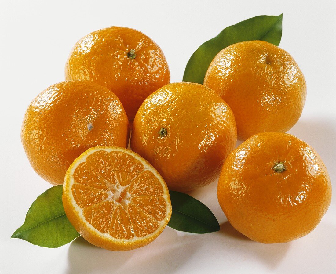 Mehrere Mandarinen, eine davon halbiert