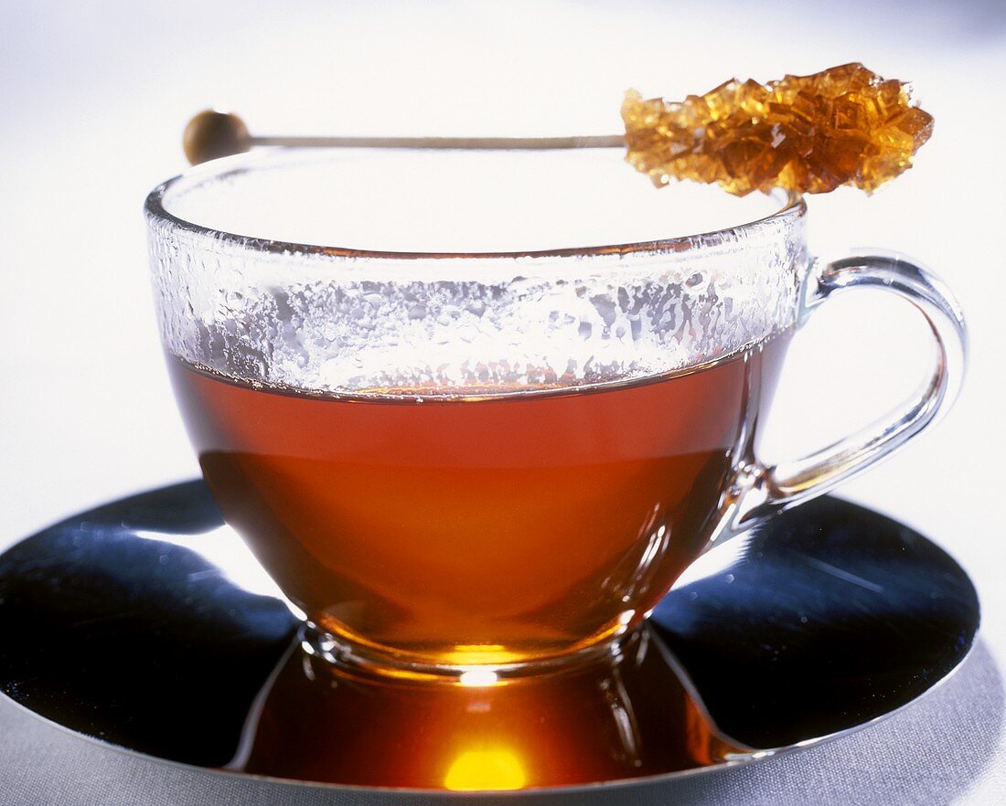 Tee in Glastasse mit Kandiszuckerstäbchen