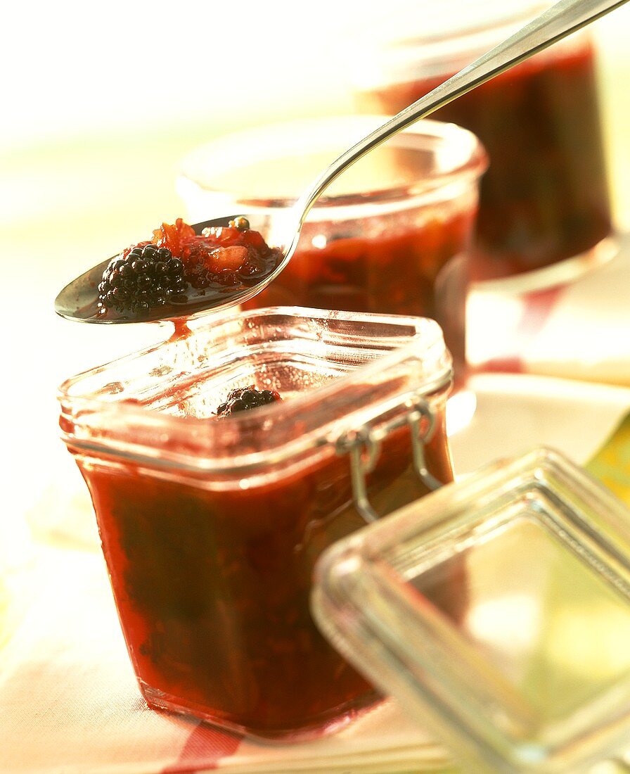 Blackberry chutney with tomatoes in jars and on spoon