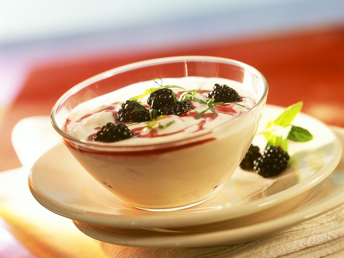 Quark dessert with blackberries and strips of mint