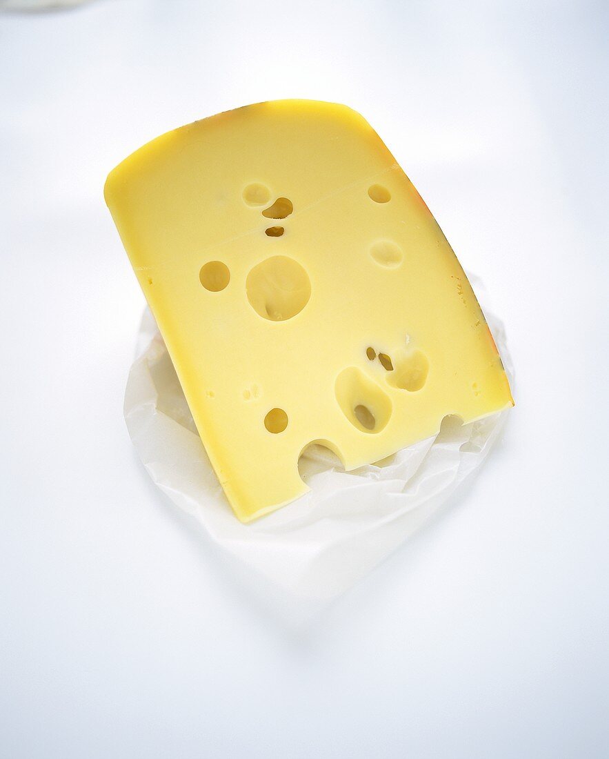 Piece of Emmental cheese on paper