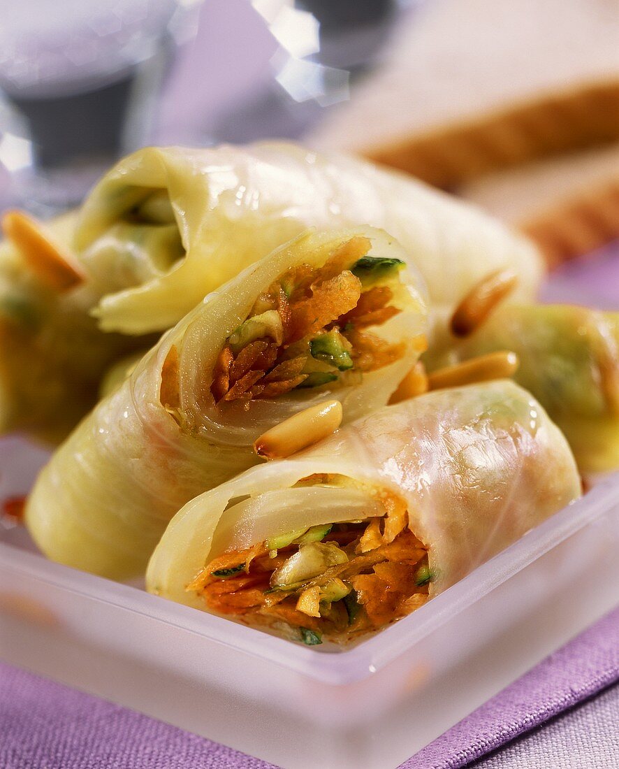 White cabbage rolls with raw vegetables and pine nuts