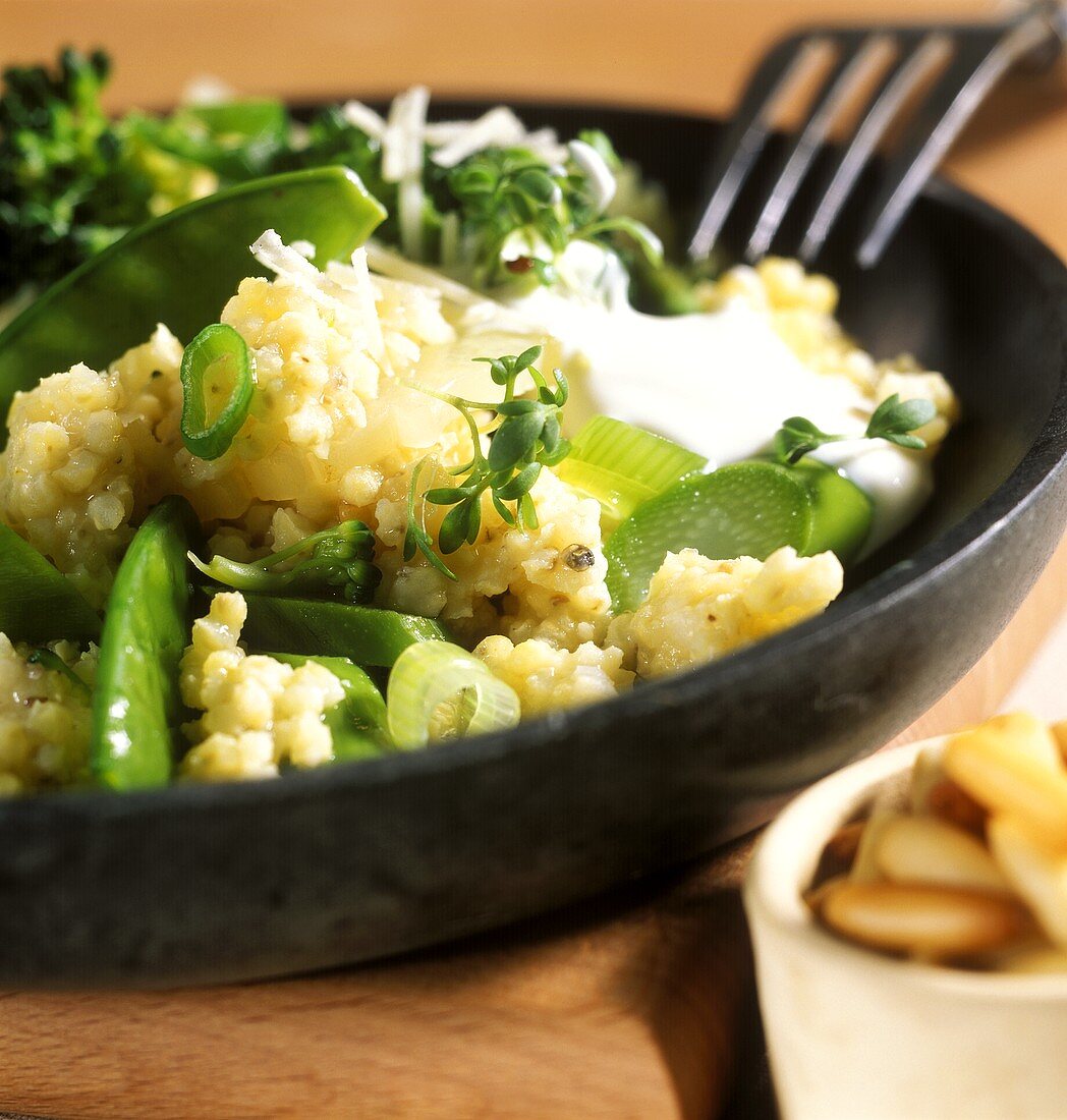 Spring millet risotto with green vegetables, cress & yoghurt