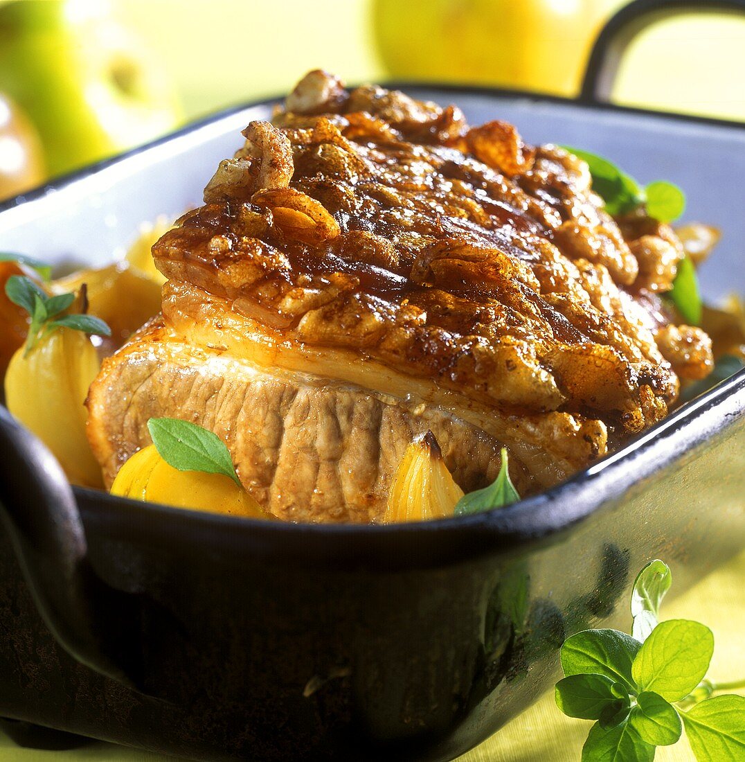 Roast pork with marjoram and apples in roasting dish