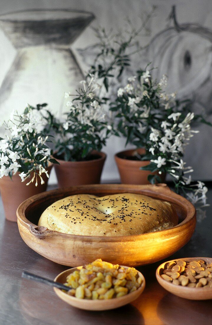 Orientalisches Fladenbrot im Tongefäss; Rosinen; Mandeln