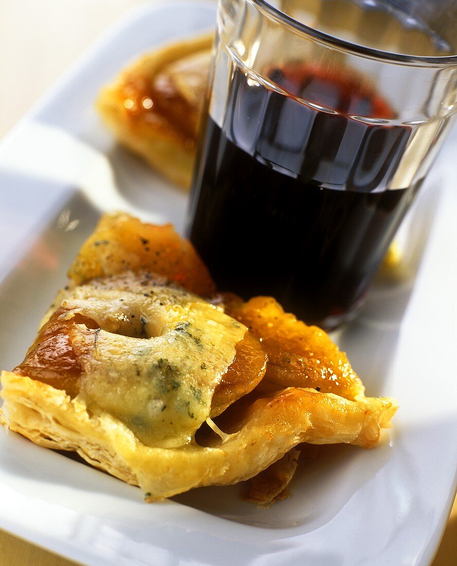 Tasty apple tart with blue cheese; red wine glass