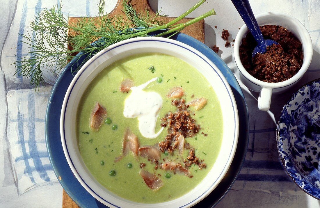 Erbsensuppe mit Matjes, Pumpernickel-Bröseln und saurer Sahne