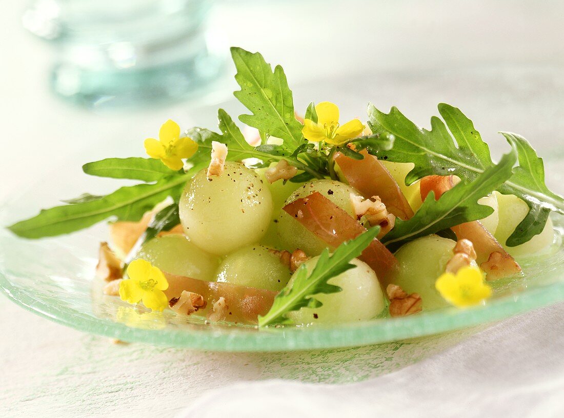 Rocket salad with melon, cured ham, nuts & edible flowers