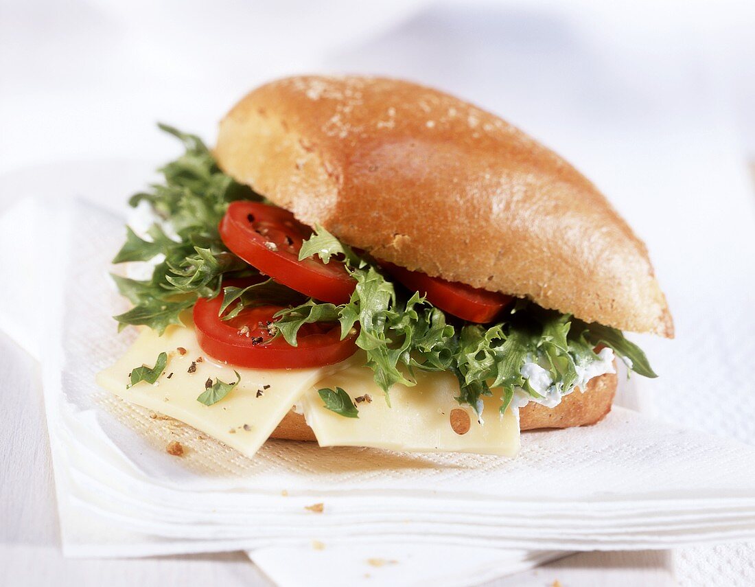 Filled roll with cheese, tomatoes & lettuces leaves