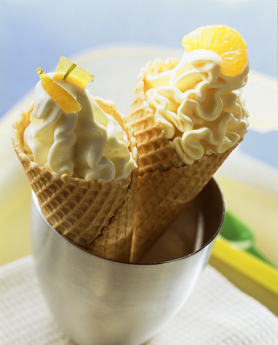 Lime quark ice cream and orange ice cream in cones
