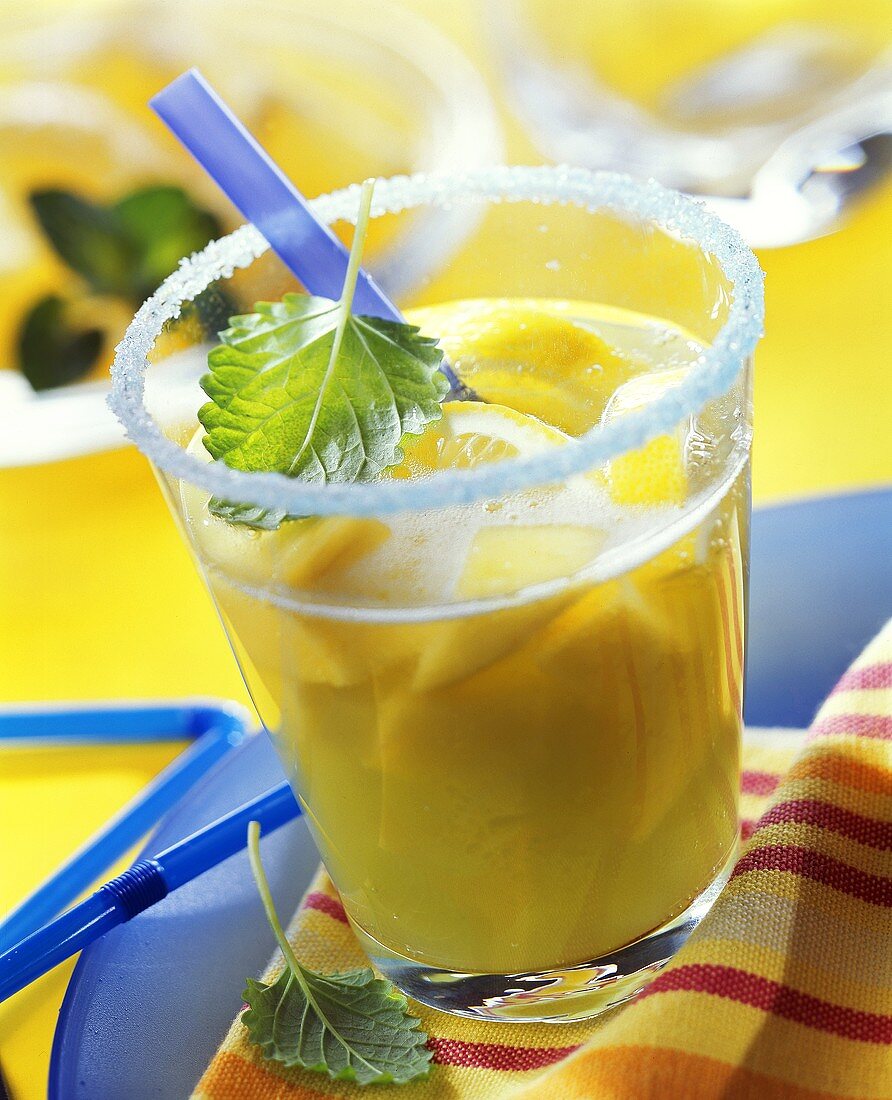 Fruit juice punch with Curacao, mango & lemon in glass