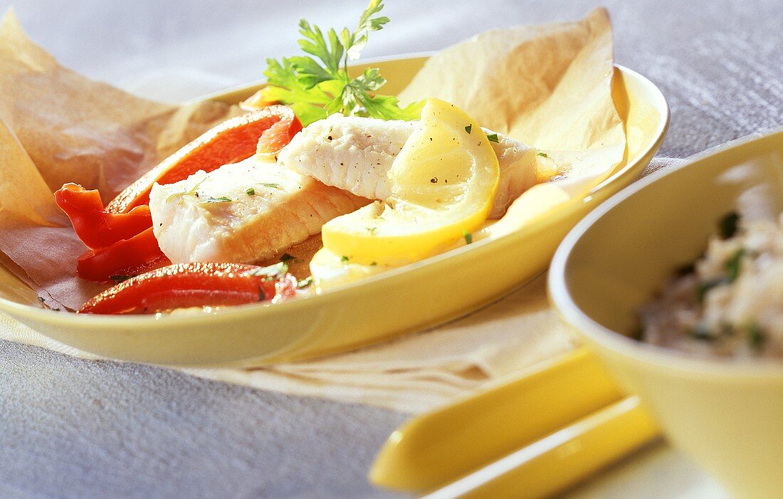 Barschfilets mit Paprika und Zitrone auf Backpapier