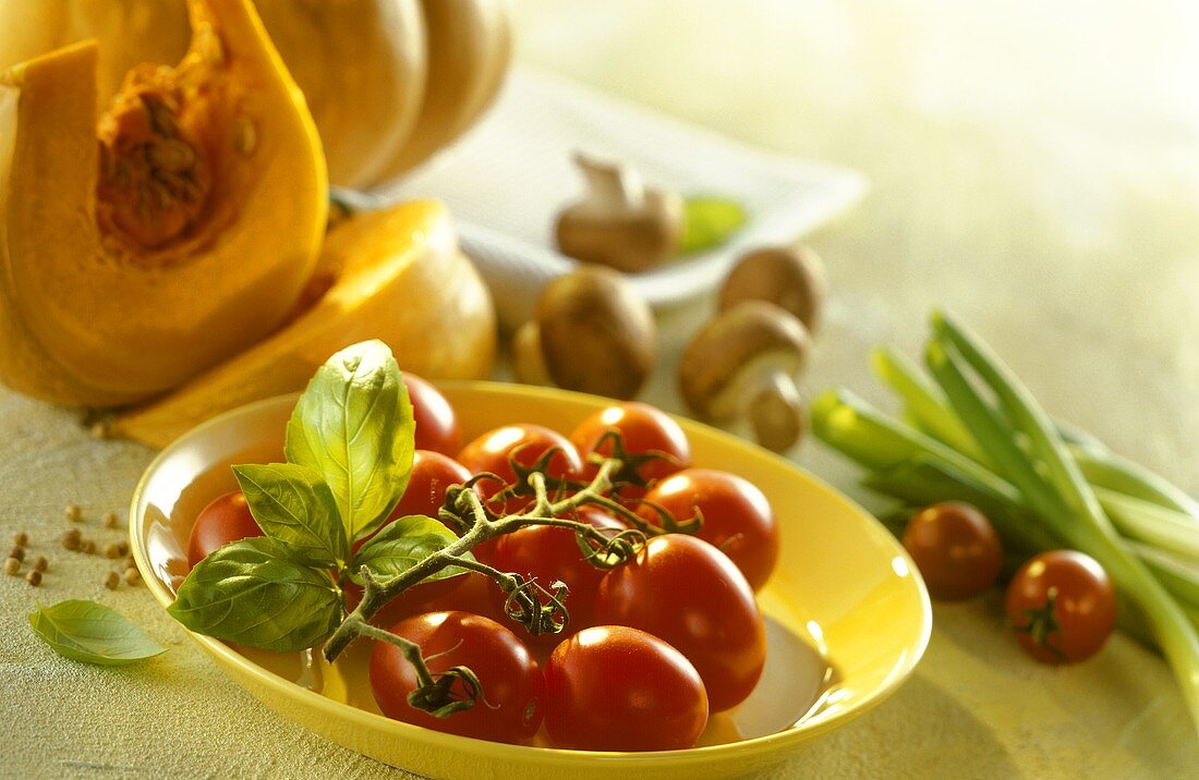 Still life with vine tomatoes, pumpkin, mushrooms and basil