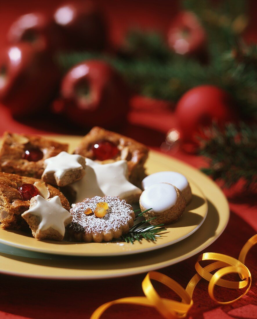 Assorted Christmas biscuits on plate; yellow bow