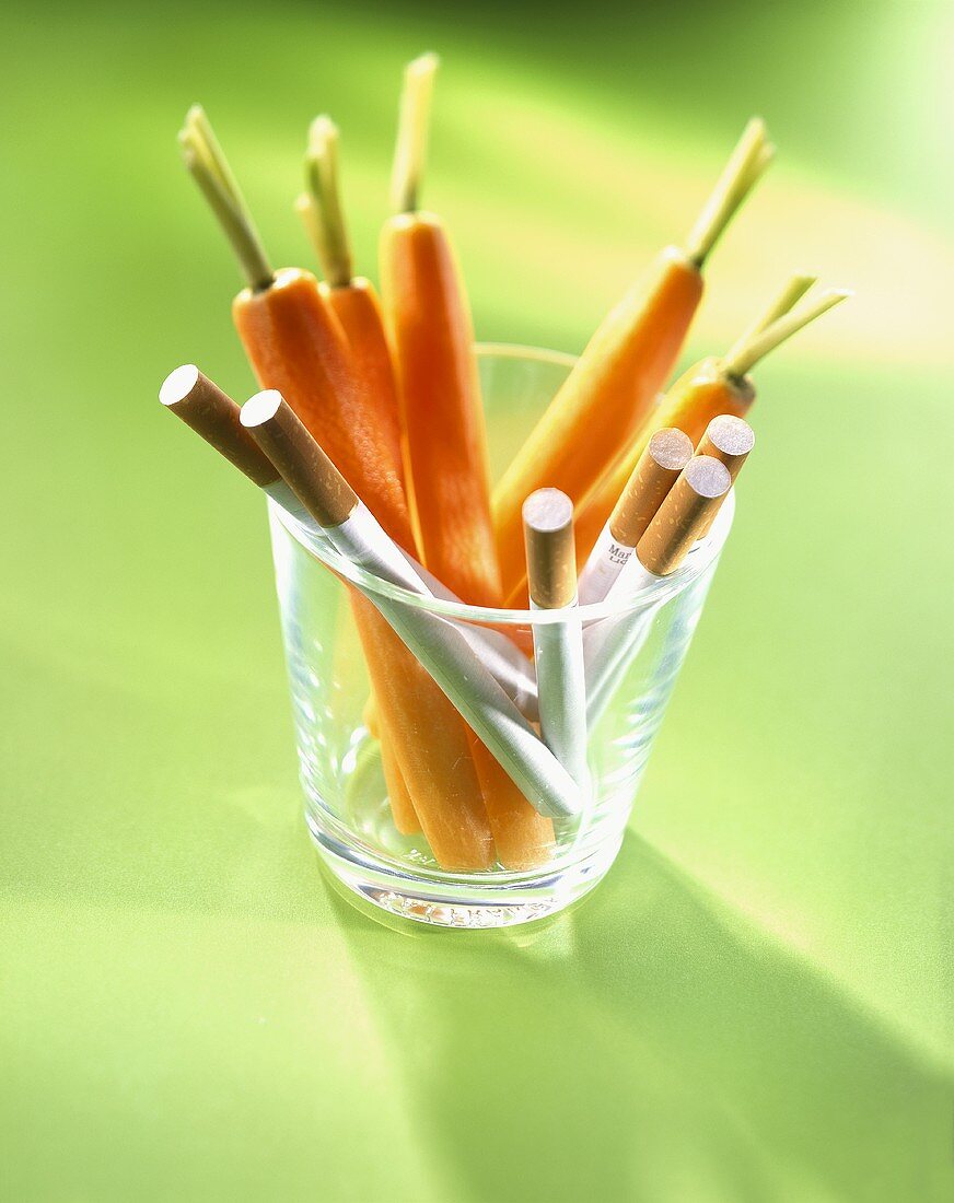 Carrots with cigarettes in glass