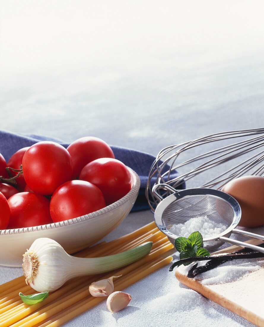 Stillleben mit Nudeln, Tomaten, Knoblauch und Backzutaten