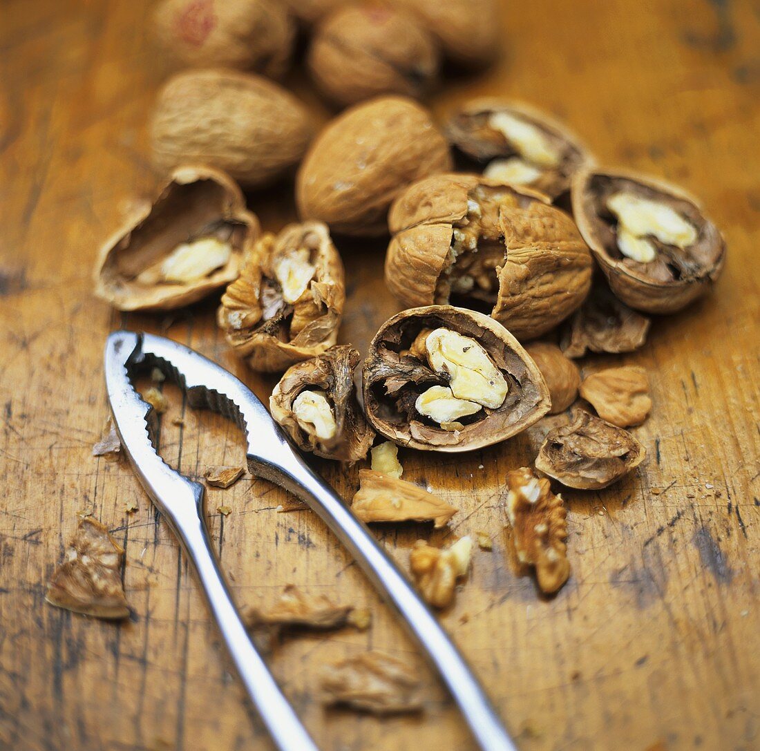 Walnuts, some opened, with nut crackers