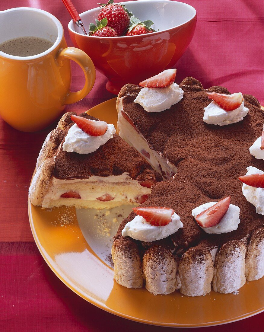 Tiramisu gateau with strawberries & cream, a piece cut