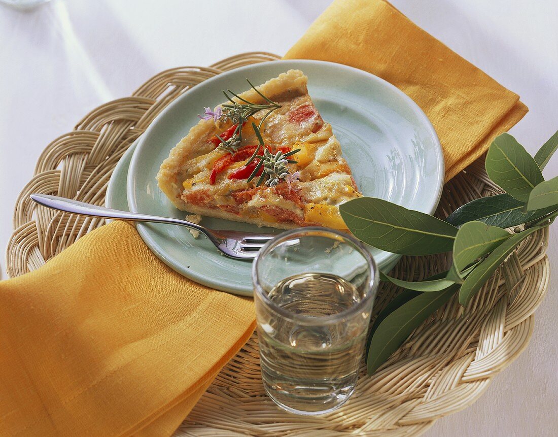 Piece of pepper quiche on plate on wicker tray