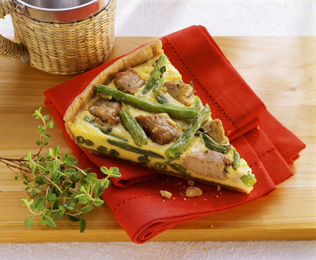 Piece of quiche with pork fillet and green beans