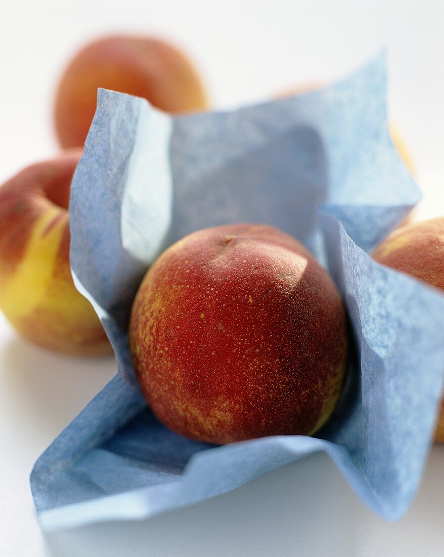 Peaches, one on blue paper