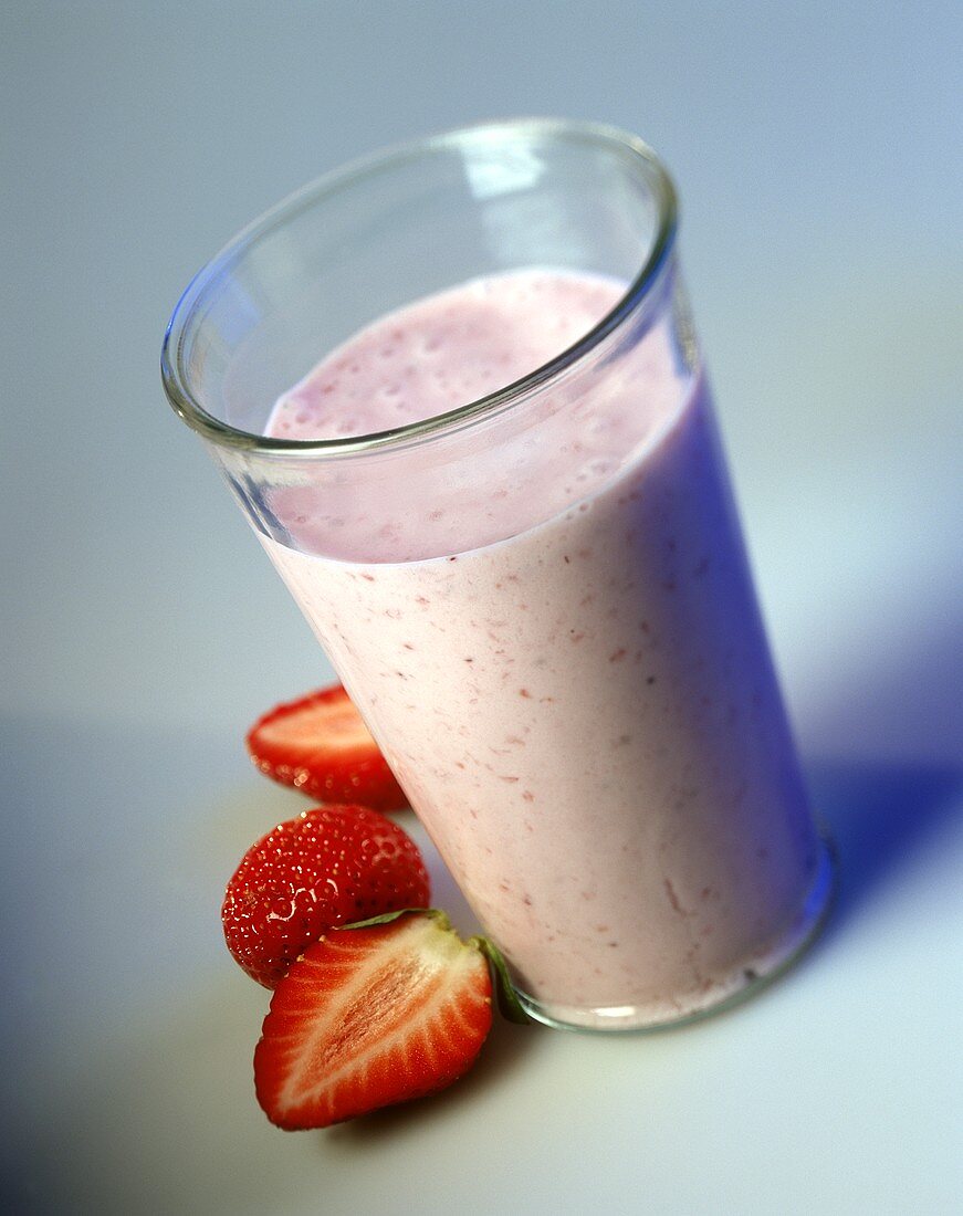 Glass of strawberry milk and fresh strawberries