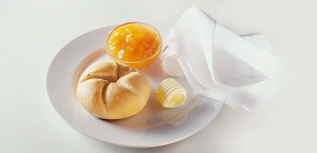 Breakfast with rolls, jam and butter curls