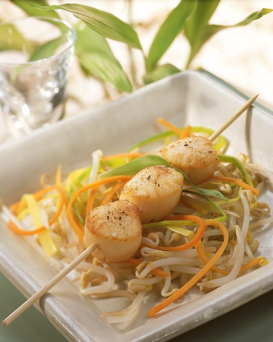 Scallop kebab on julienne vegetables and sprouts
