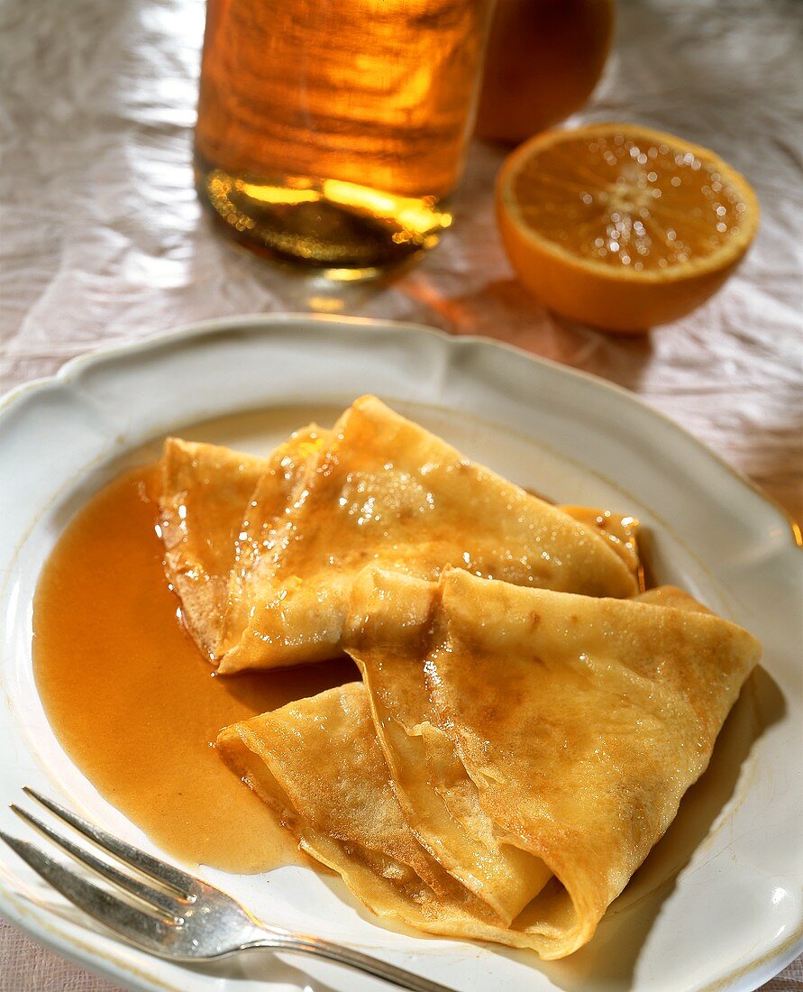 Crepes Suzette mit Orangensauce auf Teller