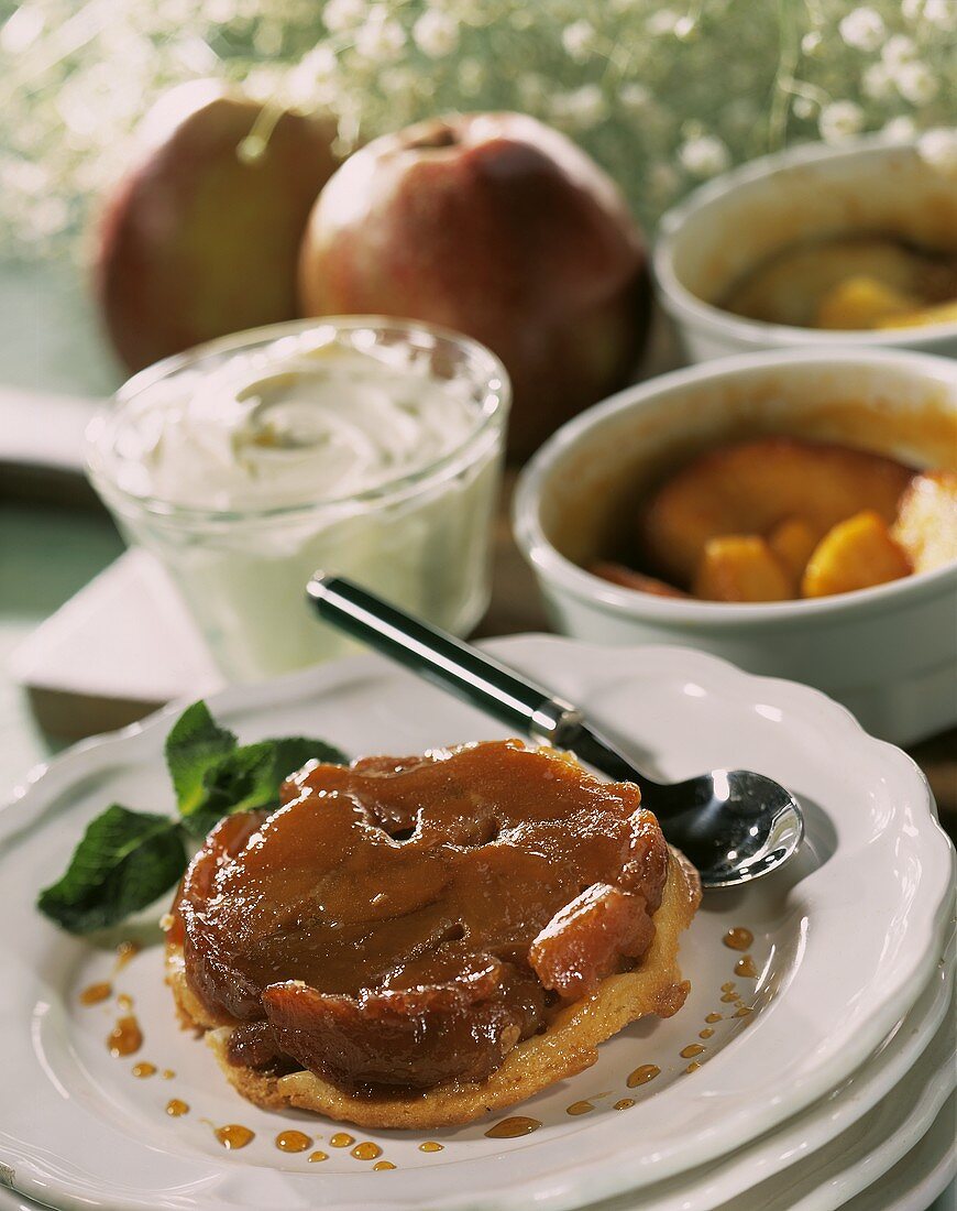 Tarte tatin on plate; cream, fresh apples