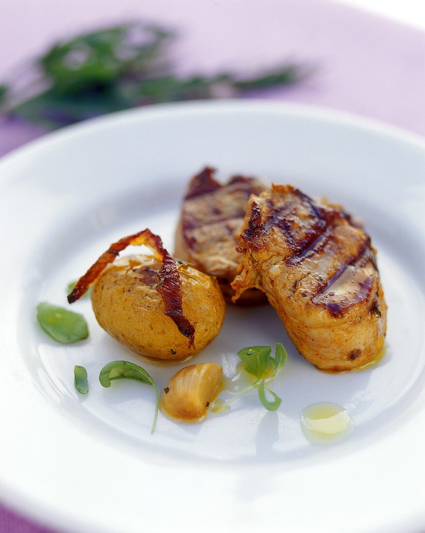 Barbecued pork fillets with baked potatoes