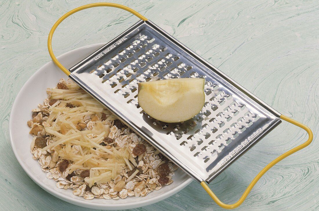 Grater and Apple on a Bowl of Muesli