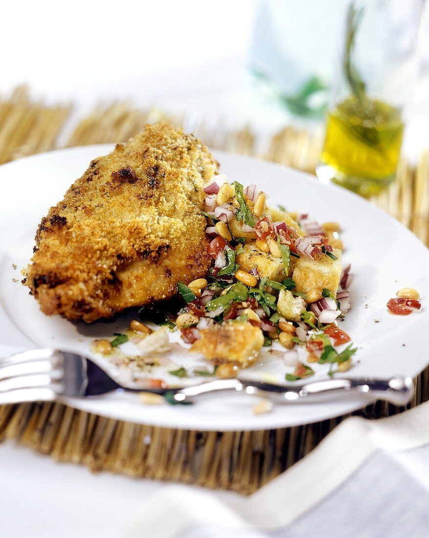 Breaded chop with panzanella and pine nuts