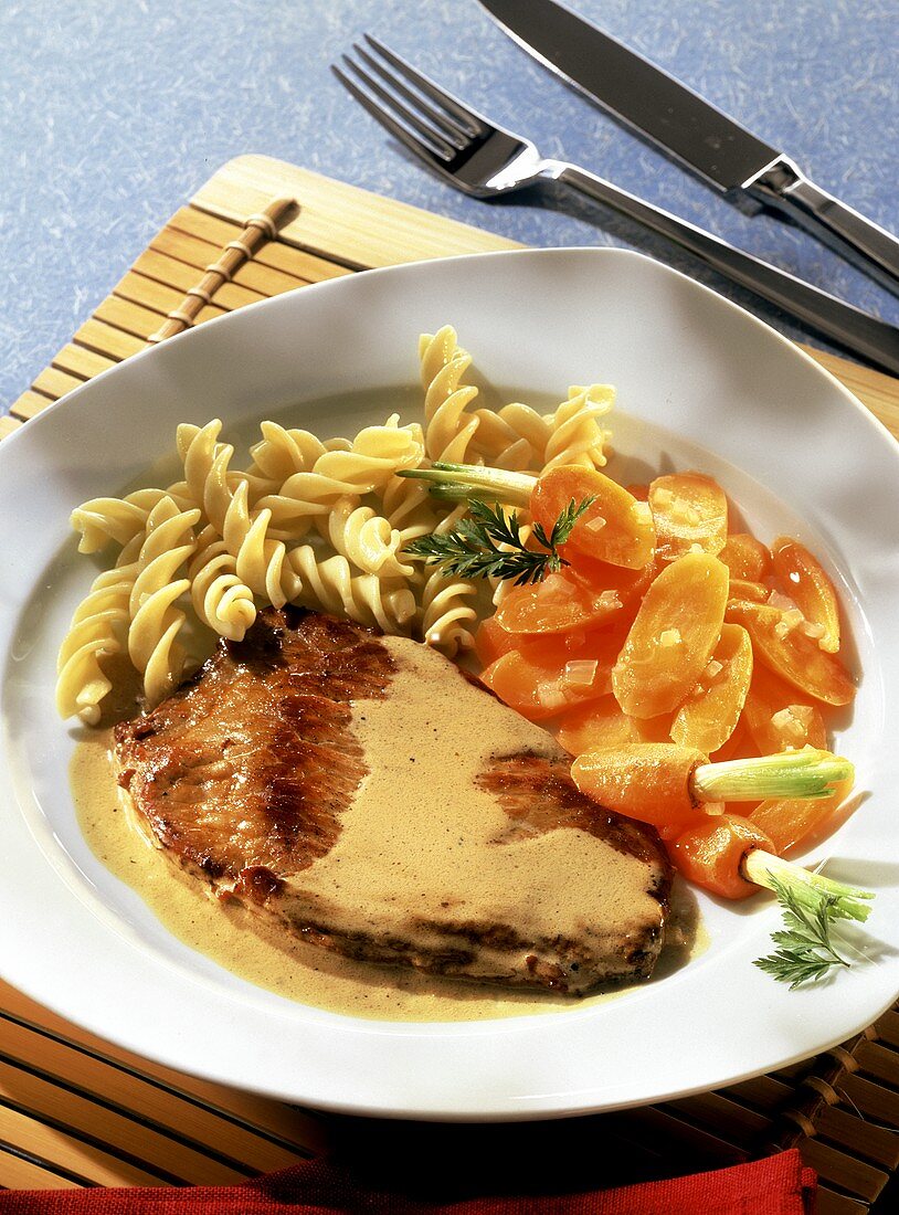 Veal escalope with cream sauce, pasta spirals and carrots