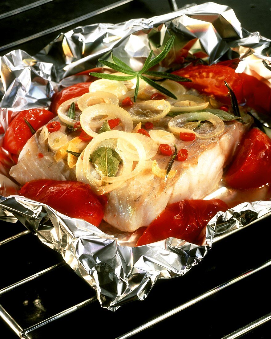 Spicy coley with onions and tomatoes, cooked in foil