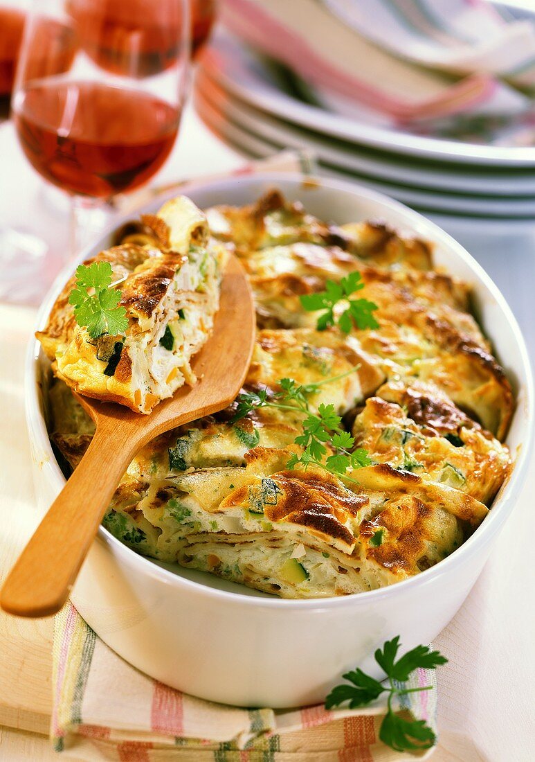 Baked pancakes in baking dish (a piece cut)