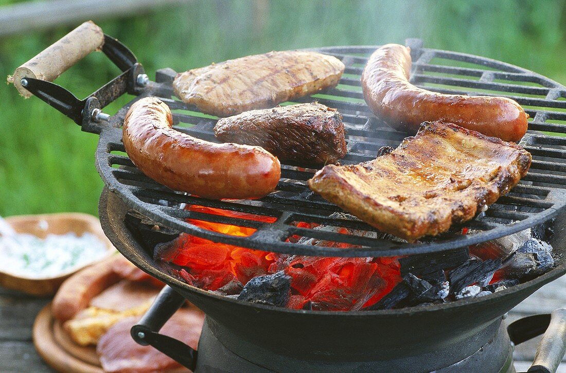 Meat and sausages on barbecue in open air