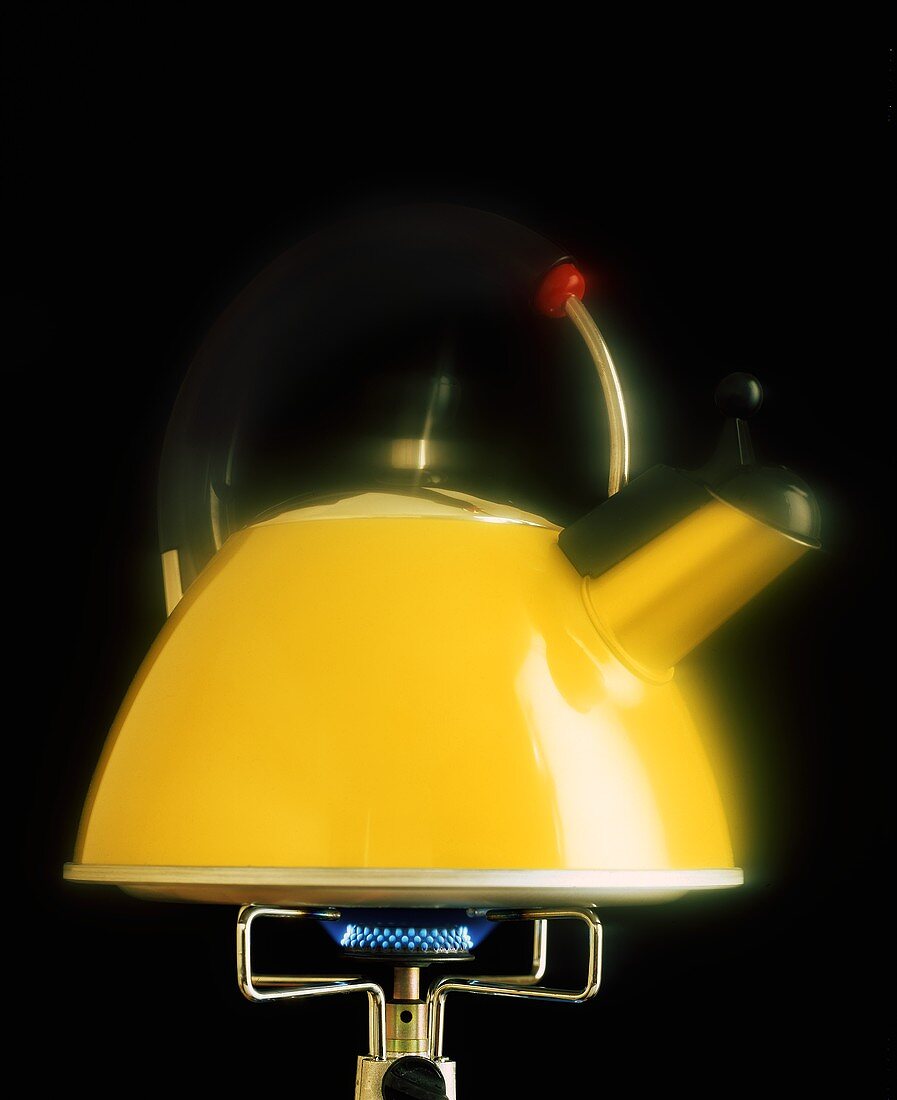 Yellow kettle on gas flame