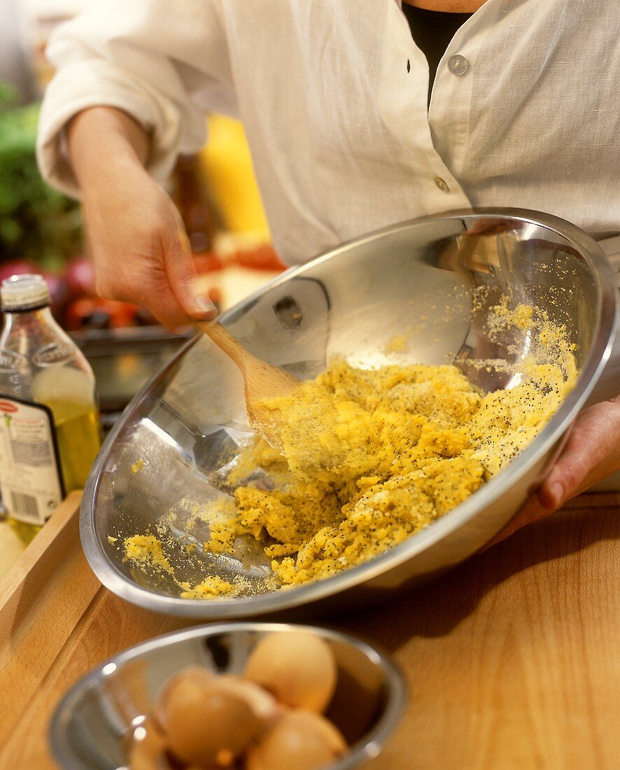Mixing polenta with olive oil in a dish