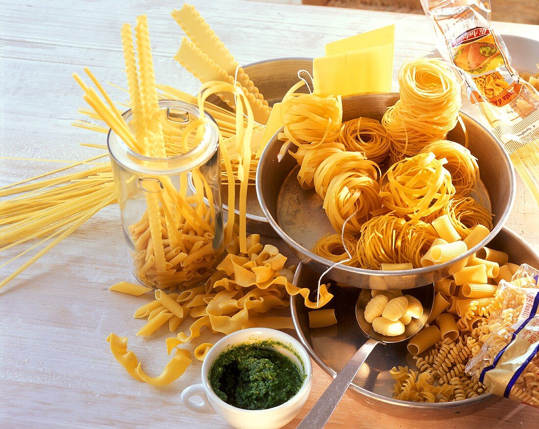 Lots of different types of pasta in dishes; pesto