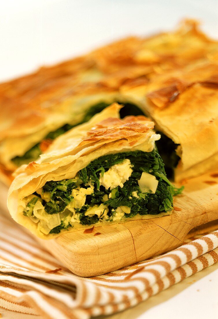 Cheese and spinach pie on chopping board