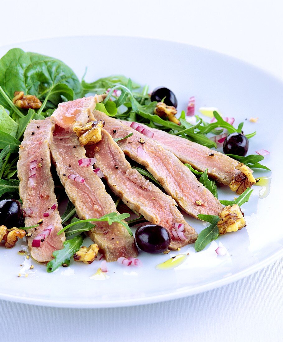 Rocket and spinach salad with tuna strips and olives
