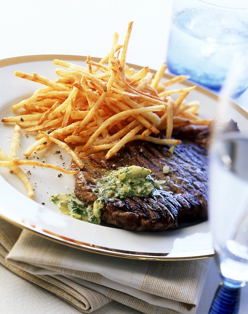 Grilled steak with parsley butter and chips