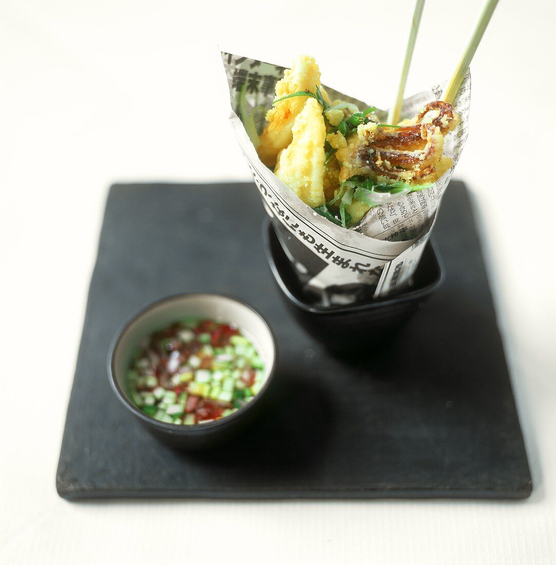 Asian cuttlefish kebabs in newspaper; spicy dip